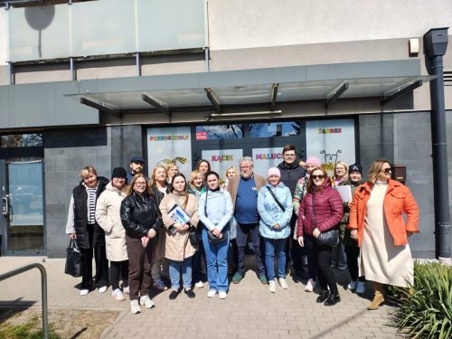 Grupowe zdjęcie przed wejściem do żłobka.