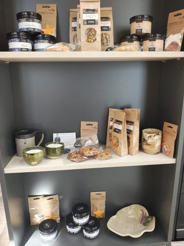 Pułki z produktami np. herbaty, miody, ciastka, świeczki itp.