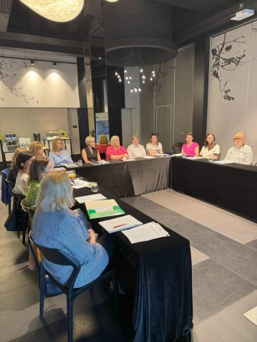Sala z stołami ustawionym w kształt litery U przy których siedzą uczestnicy szkolenia.