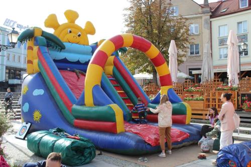 duży kolorowa dmuchana zjeżdżalnia na którym bawią się dzieci