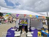 Animatorki organizujące gry i zabawy dla dzieci, przy stoisku do rysowania, XIV Podlaskich Targów Ekonomii Społecznej w ramce upamiętniającej XIV Podlaskie Targi Ekonomii Społecznej