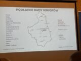 Prezentacja wyświetlona na ekranie projekcyjnym. Wyświetlony kontur województwa podlaskiego.