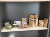 Pułki z produktami np. herbaty, miody, ciastka, świeczki itp.